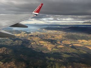 View outside of a plane window overlooking forests and hills