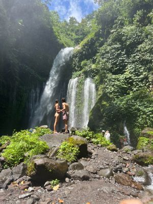 Two people standing in front of a waterfall