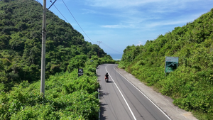 Arial footage of a motorcycle driving down the coast